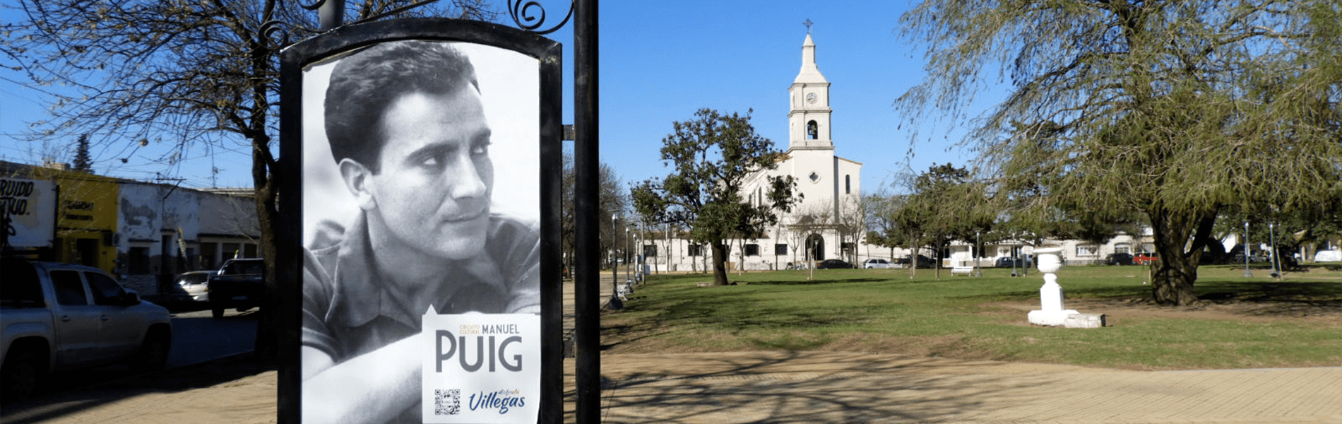 Cartel de Manuel Puig en la plaza principal.